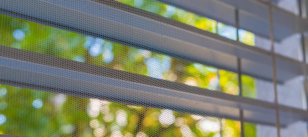 Intérieur lumineux avec fenêtre ouverte, rideaux blancs flottant dans la brise