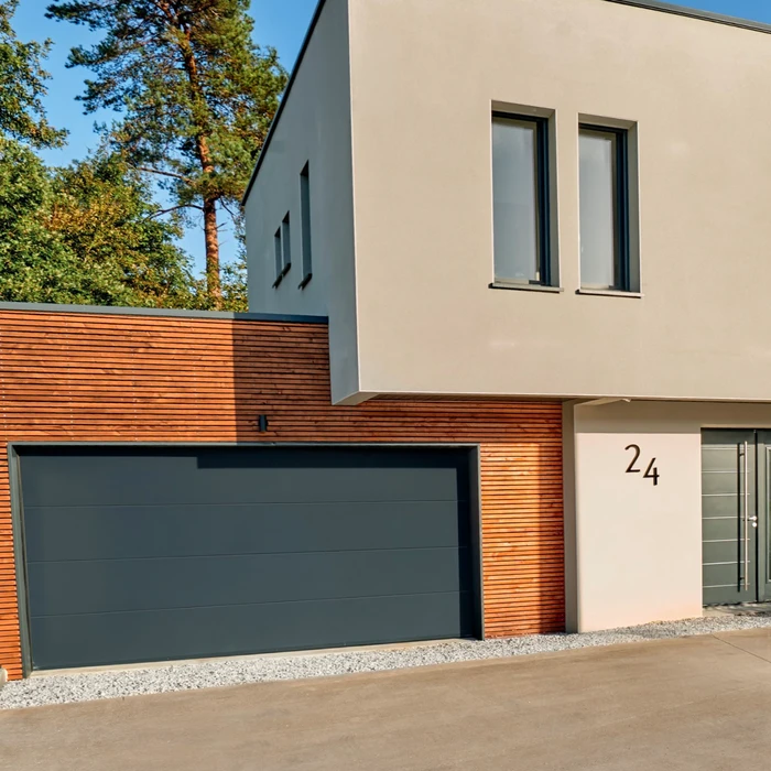 Maison individuelle moderne à étage avec façade blanche et soubassement gris anthracite