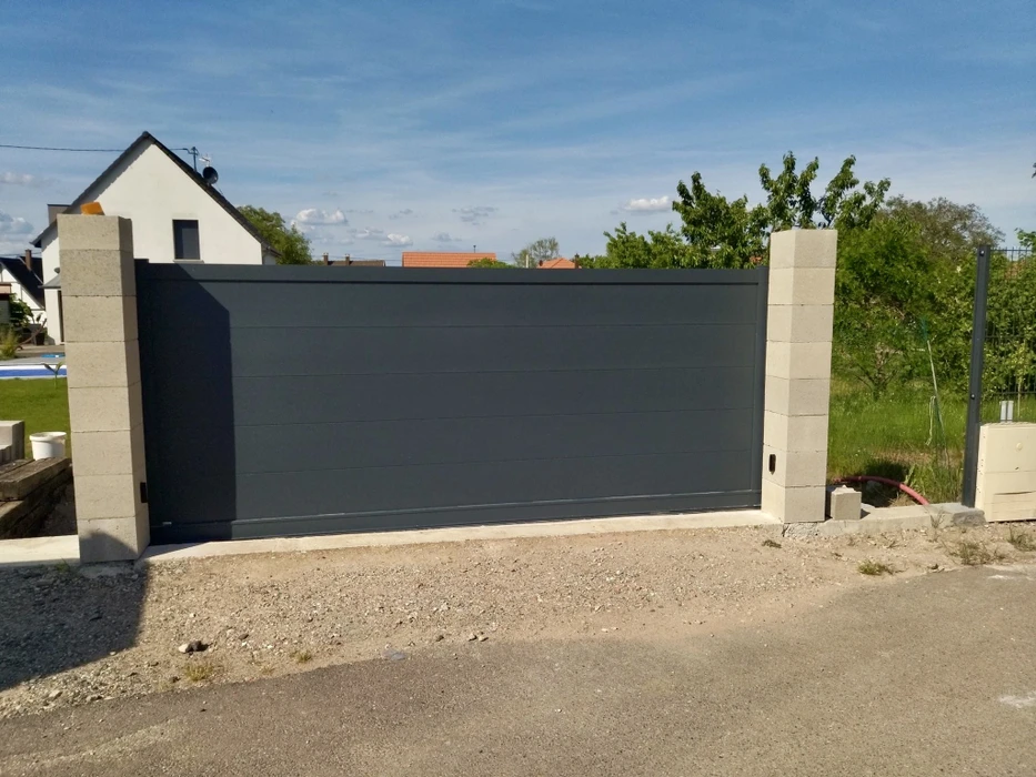Chantier de construction résidentielle avec maisons individuelles neuves à toiture en tuiles noires et façades enduites