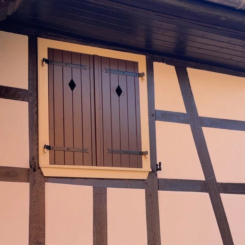 Maison contemporaine avec façade ocre et toiture en tuiles rouges, dotée de panneaux solaires photovoltaïques intégrés