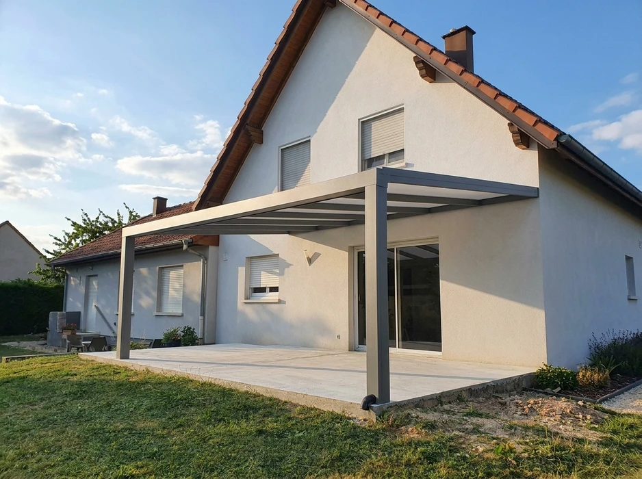 Chantier de rénovation d'appartement avec grandes baies vitrées donnant sur terrasse et toits de tuiles